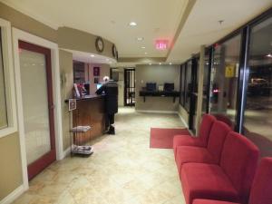 北温哥华北温哥华酒店的大楼内带红色椅子和柜台的大堂