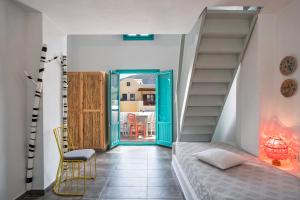 卡马利尼西亚海滩套房公寓式酒店的一间卧室设有楼梯、一张床和一张桌子
