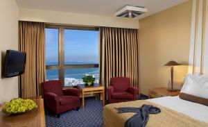 海法丹海法全景酒店的酒店客房带床、椅子和窗户