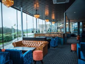 恩尼斯科西河滨公园酒店 的一间配有沙发的餐厅和一间设有窗户的酒吧