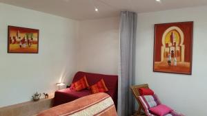 马恩河畔布里阿维斯花园皮埃尔·居里住宿加早餐旅馆的客厅配有红色的沙发和椅子