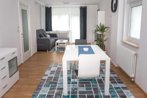 萨格勒布Apartment Jasna的厨房以及带白色桌椅的起居室。