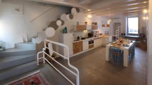 卡斯泰尔菲达尔多Relais Chambre的厨房设有楼梯,通往带桌子的厨房