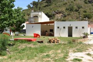 奥德赛克斯Horta do Vale - Nature House的一间白色的小房子,配有红色的椅子和一张桌子