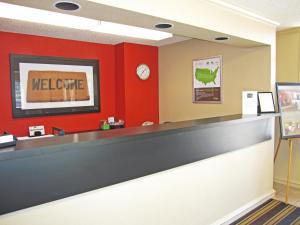 森尼维耳市美国圣何塞桑尼维尔长住酒店的一间设有迎宾台和红色墙壁的等候室