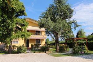 卡瓦利诺Appartamenti Giardino al Mare的黄色的房子,有树和凉亭