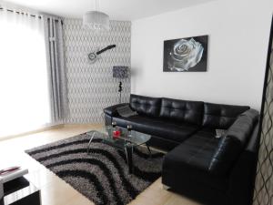 亚实基伦Avrora Luxury Apartment的客厅配有黑色真皮沙发和玻璃桌