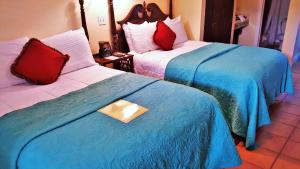 维洛海滩加勒比庭精品酒店的酒店客房带两张带蓝白床单的床。