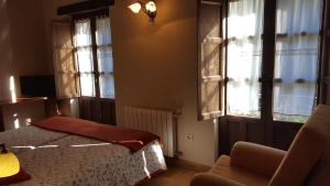 因菲耶斯托Hotel Rural Casa Cueto的一间卧室配有一张床、一把椅子和窗户。