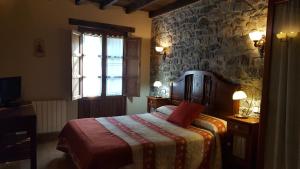 因菲耶斯托Hotel Rural Casa Cueto的一间卧室设有一张床和石墙