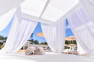 孔泽四季SPA精品酒店 的配有枕头和遮阳伞的白色天蓬床