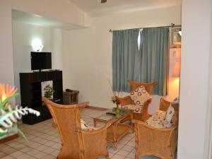 科罗尔马拉卡尔西广场酒店的客厅配有桌椅和电视