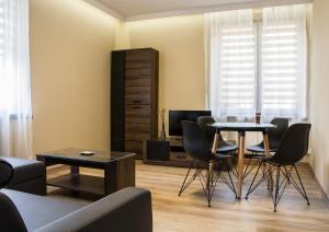比亚韦斯托克Apartments Gradowa的客厅配有桌椅和电视。