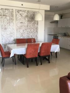 阿什杜德Shave Tsion Apartment in the center Ashdod的一间设有白色桌子和红色椅子的用餐室