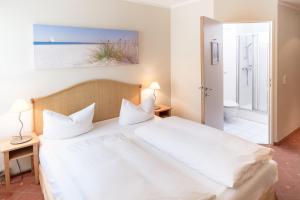 莱比锡坎帕尼尔莱比锡酒店的一间带白色大床的卧室和一间浴室