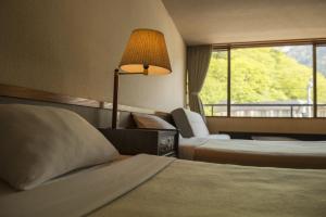 高山高山酒店的酒店客房,设有两张床和一盏灯