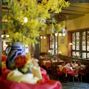 吕德斯海姆林德沃特酒店的一间带桌椅和花瓶的餐厅