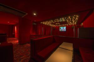 高山高山酒店的红色的房间,配有椅子和桌子及灯