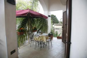 奥里亚Residence Angelica的阳台配有桌椅和遮阳伞