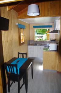 贝纳斯克Camping Aneto的带餐桌的厨房和带吧台的厨房
