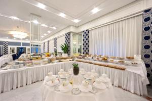 索伦托欧陆酒店的一间设有白色桌子和餐具的大型用餐室