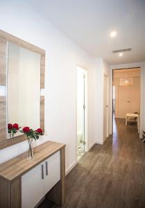 略夫雷加特河畔奥斯皮塔莱特Camp Nou Apartment的客厅配有镜子和玫瑰花瓶