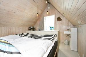 维泽桑讷Dancamps Nordsø Water Park的卧室配有一张白色大床,位于带木墙的房间内