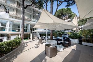 米兰马瑞提那Hotel San Marco的一个带桌椅和遮阳伞的庭院