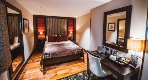 东基尔布赖德托伦斯酒店 的一间卧室配有一张床、一张书桌和一面镜子