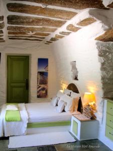 Spathi La Maison Vert Amande的卧室配有白色的床和绿门