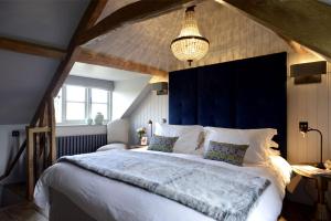 莫顿因马什沃尔纳特度假屋的一间卧室配有一张大床和蓝色床头板
