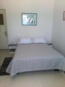 科尔丘拉卡提卡旅馆的一间卧室配有一张带白色床单的大床