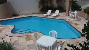 福塔莱萨普拉亚2000酒店的一个带椅子和桌子的小型游泳池