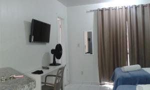 巴西利亚Asa Norte的客房设有一张床、一张书桌和电视