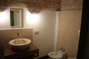 阿尔贝罗贝洛特帕柯套房的一间带水槽、镜子和卫生间的浴室
