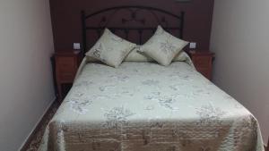 索特雷斯Treselcorral的一张带白色床单和枕头的床