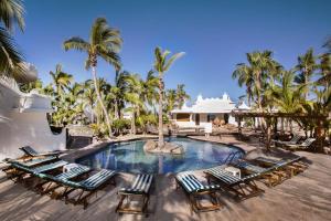 拉巴斯Hotel & Suites El Moro的一个带躺椅的度假村游泳池,并种植了棕榈树