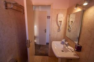 爱琴娜岛乌尔丽卡酒店的一间带水槽、镜子和淋浴的浴室