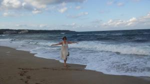 杜尼Hotel Gamartata的站在海滩上身着白色衣服的女人
