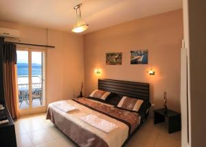 爱琴娜岛广场酒店的一间卧室设有一张床,享有海景