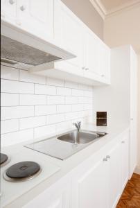 阿德莱德莫杰斯蒂克泰特街公寓酒店的厨房配有白色橱柜和水槽
