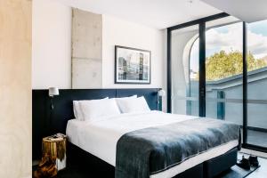 悉尼尾流百老汇公寓酒店的一间卧室设有一张大床和一个大窗户