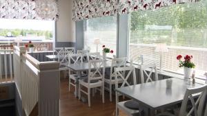 莫拉孔约斯塔酒店的餐厅设有白色的桌子、白色的椅子和窗户