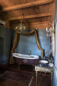罗德兹卡纳克城堡住宿加早餐旅馆的浴室配有浴缸和两个盥洗盆。