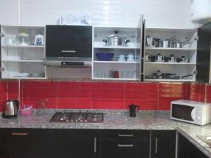 盖尼特拉Bienvenue chez vous的一间厨房,配有红色橱柜和台面