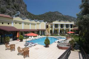 厄吕代尼兹杜高斯布提克公寓式酒店的一个带游泳池和桌椅的度假酒店