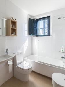 波尔托马林Hotel Pazo de Berbetoros的白色的浴室设有浴缸、卫生间和水槽。