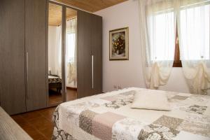 阿尔盖罗洛萨那别墅的一间卧室设有一张床和一个玻璃门