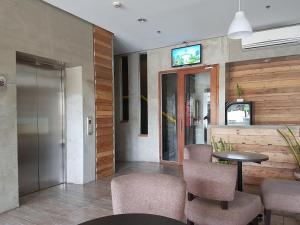 宿务宿务岛R马波罗酒店的大堂设有桌椅和电视。