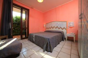 普罗斯西托角Villaggio Punta Grossa的一间设有床铺的卧室,位于一个拥有橙色墙壁的房间